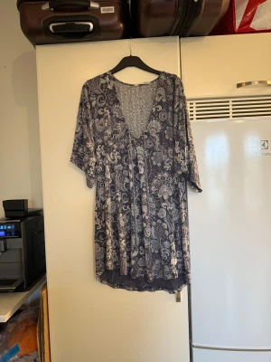 Blommig blus med v-ringning - Säljer en flowy blus i mörkblått och grått med blommigt mönster. Blusen har v-ringning, trekvartsärmar och är tillverkad i ett mjukt, tunt material som känns skönt mot huden. Perfekt för dig som gillar boho-vibes och vill ha något luftigt och snyggt. Från märket Odd Molly. Storlek 2 som enligt deras storleksguide motsvarar en M. Men den ör något rymlig. Mer använd och har tecken på användning. 