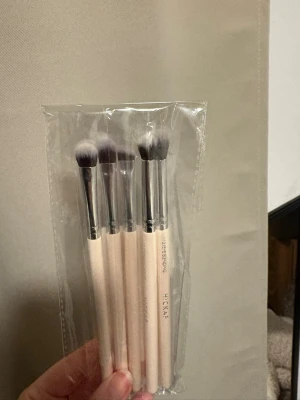 Hickap Classic Eye Set XMAS borstar - Säljer ett set med fyra ögonskuggsborstar från Hickap, Classic Eye Set XMAS. Borstarna har ljusbeige trähandtag och silverfärgade detaljer, med mjuka syntetiska borst i grått och vitt. Perfekt för att blenda och applicera ögonskugga med precision.