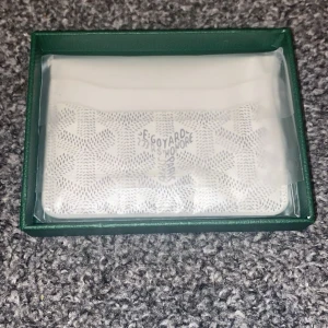 Vit mönstrad plånbok  - Snygg vit plånbok. Kommer i original grön ask med logga och autenticitetskort. Perfekt storlek för kort och cash, och riktigt clean design som sticker ut.