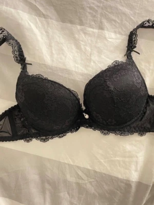 Svart spets-bh med push up - Snygg svart bh med spetsdetaljer och vadderade kupor. Köpt på shein och då stig storleken bara i S, men skulle väl säga för de som har ungefär A kanske B i bh storlek. HELT OANVÄND!!! Kvaliteten är hur bra som helt, inget felköp den alls, känns dyr