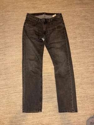 Gråa Jeans från LEE 33/36 - Snygga och fräscha Jeans från Lee, riktigt sköna och sitter perfekt. Strlk 33/36 men passar 34 perfekt. 