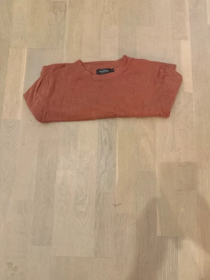 Rostbrun stickad tröja Dressmann - Snygg rostbrun stickad tröja från Dressmann i storlek L. Tröjan har rund hals och långa ärmar, perfekt för dig som gillar enkel och stilren design. Materialet är mjukt och skönt, passar bra till jeans eller chinos. Färgen är varm och höstig.