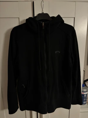 Hugo boss hoodie svart - Svart Hugo boss hoodie i fint skick, saknar ett ”U” och ”S” men inget som stör.