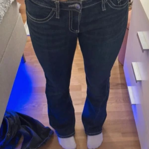 Mörkblå bootcut jeans Gina Tricot 158 - Snygga mörkblå jeans från Gina Tricot i storlek 158. De har bootcut design kontrastsömmar och  bakfickor med lock och knapp. Klassisk femficksdesign. Storlek 158, kan ha lite tecken på användning..