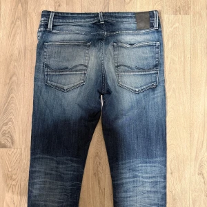 Jack & Jones Jeans Slim Glenn Blå W32 L34 - Sjukt feta och eftertraktade blåa Jack & Jones Slim/Glenn jeans i storlek W32/L34 i en snygg fade och slitningar. Mått: Midja - 42,5cm, Benlängd: 109cm. Hör av dig vid funderingar!🤩