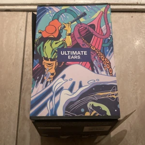 Ultimate Ears On-Ear Hörlurar Rosa - Snygga rosa on-ear hörlurar från Ultimate Ears. Levereras i originalförpackning med manual. Hörlurarna ser ut att vara i mycket gott skick, utan synligt slitage. Perfekt för musik, spel eller videosamtal. Bekväm passform och trendig design.