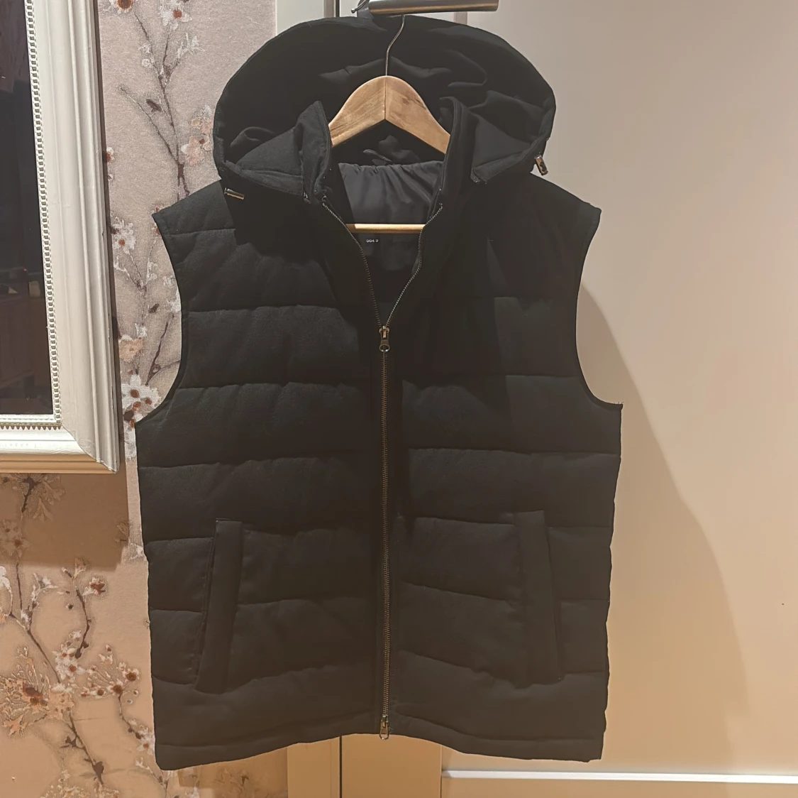 Svart dunväst med huva och dragkedja