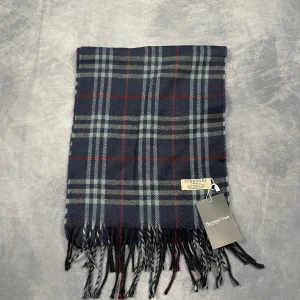 Burberry Halsduk - Skick: 7/10 (Vintage), begagnad, inga defekter. | Vad som ingår: Endast halsduken. | Ordinarie pris: +- 4000 SEK / 400 €. | ​​OBS: Halsdukarna finns i samma färgsättning men kan skilja sig något i modell eller detaljer, beroende på tillverkningsår eller kollektion