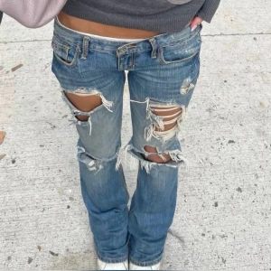 Blå lågmidjade jeans från Hollister - Säljer dessa superfina jeans från Hollister med slitningar då de inte kommer till användning. De är super Lågmidjade och säljs inte längre. 💞 De är storlek 0s och jag har storlek 25 i jeans och de passar mig perfekt. Kom privat för fler bilder eller om du har frågor 💕De två första bilderna är från Pinterest och de är exakt samma jeans bara att hennes har lite fler hål🫶🏼