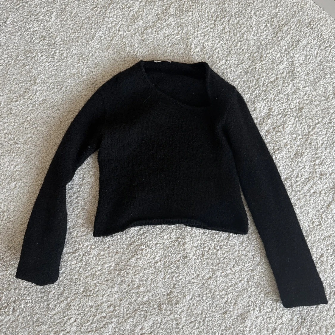 Svart stickad tröja med asymmetrisk hals - 1