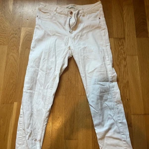 Vita Molly jeans från Gina Tricot - Säljer ett par vita Molly jeans från Gina Tricot med skinny passform och klassisk femficksdesign. Jeansen har knapp och dragkedja framtill samt bälteshällor. Perfekt för dig som gillar ljusa och tighta jeans.