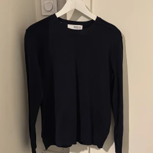 Mörkblå långärmad tröja Selected - Snygg mörkblå långärmad tröja från Selected med rund hals och ribbad nederkant. Enkel och stilren design som funkar till jeans eller chinos. Tillverkad i mjuk bomull som känns skön mot huden. Perfekt för dig som gillar minimalistisk stil.