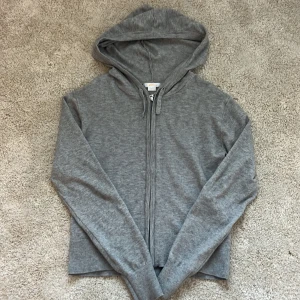 Zip hoodie från Gina Tricot - Mysig zip hoodie från Gina Tricot med dragkedja framtill och huva med snörning. Tröjan är i mjuk bomullsmix och har långa ärmar samt ribbade ärmar. Storlek 158-164 fast är liten i passform så skulle säga storlek 146-152. Har knappt använts pga att den varit för liten