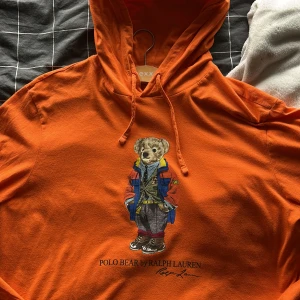 Orange hoodie Polo Bear Ralph Lauren - Säljer en orange hoodie från Ralph Lauren med Polo Bear-tryck på bröstet. Nyskick storlek XL 