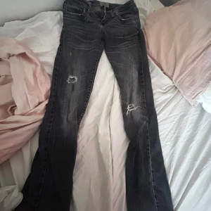 Svarta bootcut jeans från LTB - Snygga svarta jeans från LTB med bootcut passform och slitna detaljer på benen. Modellen heter valerie och är storlek 26/32 men eftersom dom är klippa på botten skulle jag säga att dom är 26/30