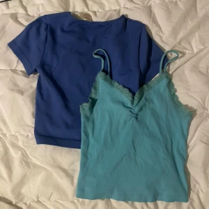 Blå t-shirt och turkos linnetopp - Säljer en enkel blå t-shirt med korta ärmar och rund hals, samt en turkos linnetopp med spetsdetaljer vid halsringningen och smala axelband. Linnetoppen har en ribbad struktur och v-ringad form. Perfekt för dig som gillar färg och snygga detaljer. XS-S