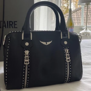Zadig Voltaire  - Säljer nu min Zadig & Voltaire väska. Helt ny, men sitter inte kvar någon prislapp på eftersom jag använt den 2 gånger. Säljer pga att det finns annat jag är intresserad utav att köpa istället. Inga defekter eller liknande. Som ny! Den är självklart äkta. Kvitto, äkthetsbevis samt dustbag finns och skickas även med vid köp. Viss prutmån finns, men inga orimliga bud. Köpt för 5100kr. Hör gärna av er 😇