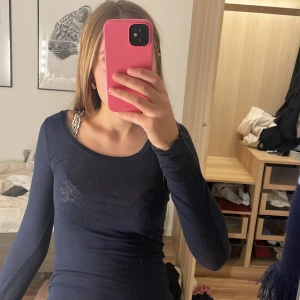Mörkblå långärmad tröja från Intimissimi - Säljer en tunn och mjuk mörkblå långärmad tröja från Intimissimi. Tröjan har rund halsringning och sitter tight mot kroppen, perfekt för lager-på-lager eller som enkel bas. Tröjan är lite genomskinlig och har lite små fläckar men som går att tvätta bort och kommer såklart tvätta innan jag postar grejer. Materialet är bomull med lite stretch för skön passform. Jag har nästan aldrig använt tröjan. Pris kan sänkas.