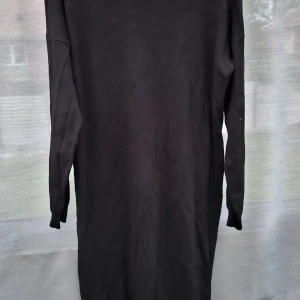 Svart lång stickad klänning storl.S  - En svart långklänning i stickat material med långa ärmar och ribbade muddar. Enkel och stilren design som passar perfekt till kyligare dagar. Klänningen har en rak passform och är mjuk och bekväm att bära. Klänningen har ett sprund I båda dimmorna. Inte så tjock.Djur och rökfritt hem mycket fint.  Nylon o viskos