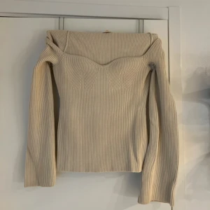 Beige ribbad långärmad topp - Beige ribbad topp från H&M med lång ärm och markerad byst. Toppen har en fyrkantig urringning och är figurnära i modellen. Storlek M men kan sitta som S med 
