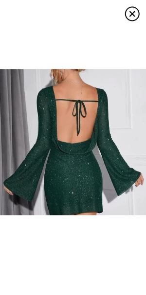 Nyårs klänning med öppen rygg - Supersnygg grön klänning med glittrigt tyg, vida långa ärmar och öppen rygg. Perfekt till nyår