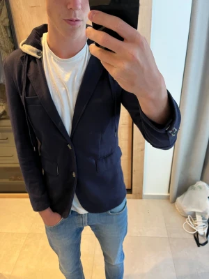 Mörkblå kavaj med huva från Alcott & Co - Snygg mörkblå kavaj med huva från Alcott & Co i storlek medium.                                                            —————————————————————————                                                              📐| Storlek: M                                                          👕| Märke: Alcott & Co                                           🔎 | Skick: Bra skick                                                ✍🏻 | Skriv om du har några frågor