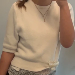 Vit stickad tröja - Säljer en vit stickad tröja med trekvartsärm. Tröjan har rund halsringning och mjukt material som känns skönt mot huden. Perfekt för dig som gillar stilrena och gulliga plagg. 