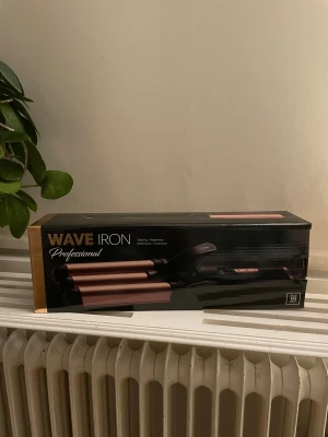 Vågtång - Säljer en vågtång ”wave iron professional” 155 watt och har keramisk beläggning. Justerbar temperaturinställning 100-200 grader och ger jättefina beach waves. Testad en gång men säljer då den aldrig kommer till användning. Med tillkommer även en värmetålig handske🩷rengörs noga innan den skickas🩷köpt för 399 kr