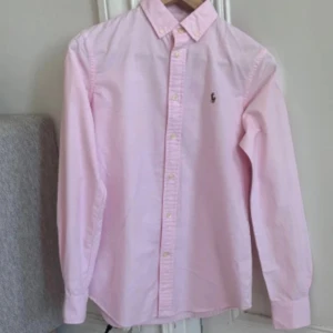 Rosa Ralph Lauren Skjorta - Fin Ralph lauren skjorta som knappt är använd. Väldigt bra skick. Storlek 6= Smal