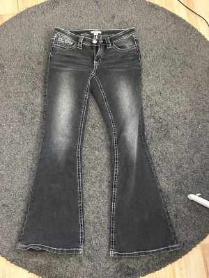 Gina Tricot Young 14+ jeans  - Grå low waist bootcut jeans från Gina Tricot med snygga markerade sömmar. Säljer då dom är för stora och är endast använda ett fåtal gånger. 