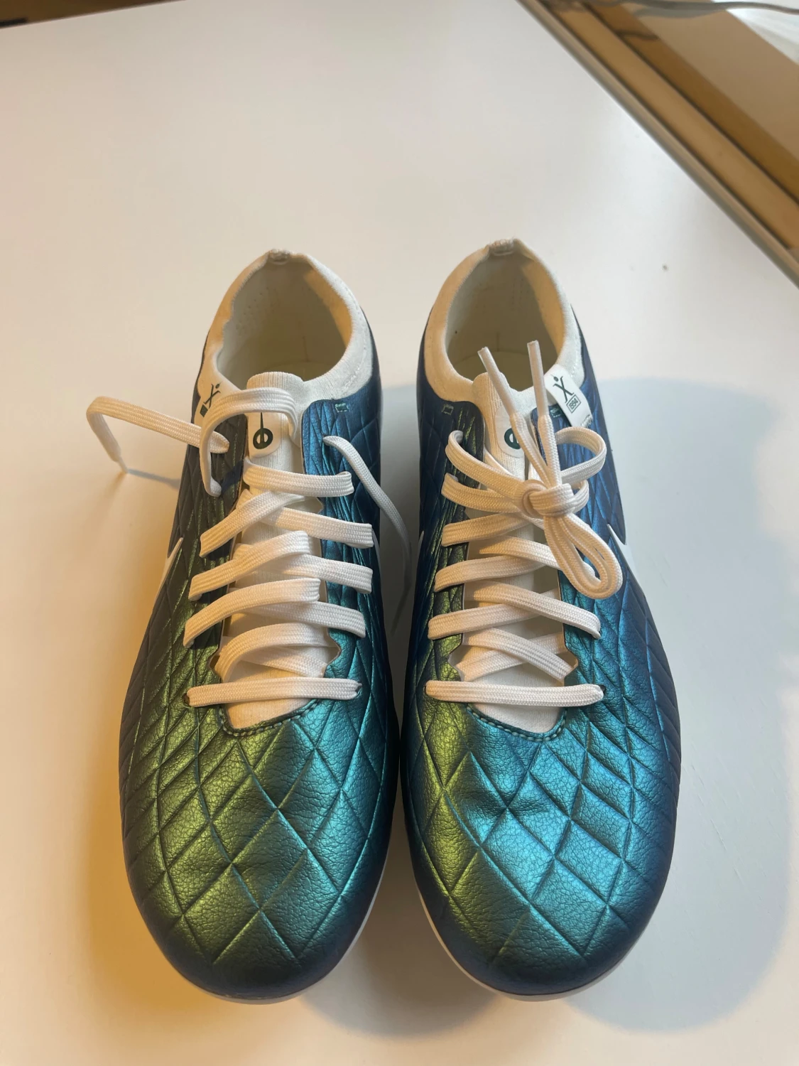 Detta är en fotbollssko av modellen Nike Tiempo Legend 10 Elite FG i en blå/grön iriserande färgvariant. - 1