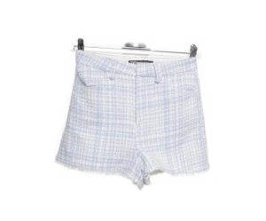 Blåvita rutiga shorts från Zara - Supersnygga blåvita rutiga shorts från Zara i en högmidjad modell. De har fransiga kanter, bälteshällor och fickor både fram och bak. Materialet är mjukt och strukturerat, perfekt för en fräsch och trendig look.