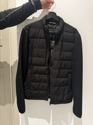 Svart pufferjacka med dragkedja - Svart pufferjacka från Zara med quiltad framsida och slät baksida. Jackan endast använd 1 gång!