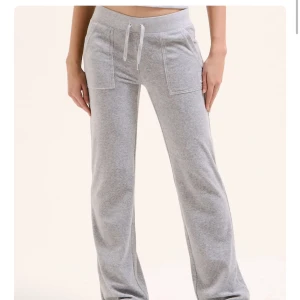 Grå mjukisbyxor med snörning - Snygga grå mjukisbyxor med bred resår i midjan och snörning framtill. Byxorna har raka ben, stora fickor fram och bakfickor med knappdetaljer. Perfekta för chill dagar och har en loose passform.