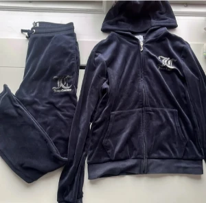 Juicy Couture mörkblå set - Mörkblå mjukiskläder från Juicy Couture med logga. Byxorna har snörning i midjan. Passformen är loose med lätt bootcut. Supermysigt!! men har tyvärr blivit för litet för mig.