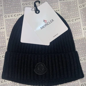 Svart moncler black patch mössa  - Splitterny moncler vintermössa men svart märkte för exklusivtet.Medföljer monclerplastpåse för förvar när den inte används.  Unisex / Onesize finns i Göteborg. 