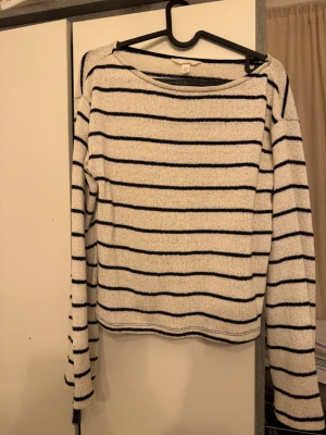 Vit och svart randig stickad tröja H&M - Säljer en vit stickad tröja från H&M i storlek XS med svarta horisontella ränder. Tröjan har lång ärm och en rak, lite loose passform. Materialet är mjukt och skönt, perfekt för att chilla eller hänga med kompisar. Enkel och stilren design som funkar till jeans eller kjol.