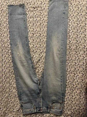 Levi's 501 ljusblå jeans straight fit: W31 L34 - Klassiska Levi's 501 jeans i ljusblå tvätt med raka ben och femficksmodell. Jeansen har den ikoniska läderpatchen bak och röda Levi's-tag på bakfickan. Tillverkade i slitstarkt bomullsjeans, perfekt för en avslappnad och tidlös look.