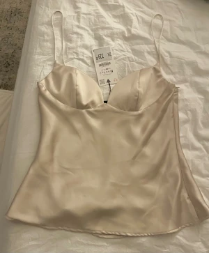 Satin linnetopp från Zara - Säljer en champagnefärgad topp från Zara. Aldrig använd och prislapp sitter kvar! 