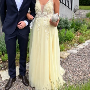 Gul Balklänning - Säljer min super super fina balklänning. 🌸🥺Den är inköpt för 5000 och har därefter vart hos skräddare för sy in midjan och sy upp banden. Den är nu i cirka storlek 36. Jag är vanligtvis en storlek 36/S och är 167 cm lång som referens. Är i jättefint skick. Skriv gärna för fler bilder och frågor. ( Om man vill kan man få köpa till väskan för en billig peng)🥰