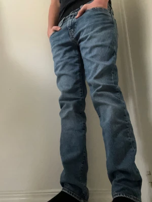 Levi's blå jeans straight fit - Riktigt snygga blå Levi's jeans med rak passform. De är också storlek 32 men uppsatta till 30 i L.. Bra passform runt benen och inga defekter på byxorna.