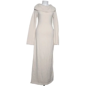 Stickad långklänning från Gina Tricot - Säljer en snygg stickad långklänning från Gina Tricot i mjuk beige ton. Klänningen har lång ärm, bred krage som går ner över axlarna och en figurnära passform. Perfekt för dig som gillar stilrena och mysiga plagg med lite extra edge.
