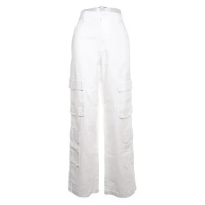 Vita cargopants med hög midja - Snygga vita cargopants med hög midja och breda ben. Byxorna har flera stora fickor på sidorna och en loose passform som ger en avslappnad vibe. Perfekta för dig som gillar streetstyle och vill sticka ut med en fräsch look.