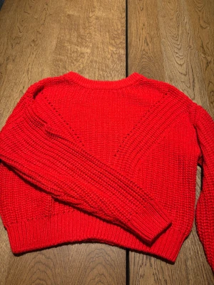 Röd stickad tröja från H&M Divided - Snygg röd stickad tröja från H&M Divided i storlek S. Tröjan har grovstickad struktur, rund hals och långa ärmar med ribbade muddar. Perfekt för att ge din outfit en färgklick och passar perfekt nu till julen! 🎅 