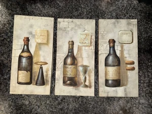 Vinflask tavlor - Bundle: 499                                                               Separat: 199                                                            Snyggt konsttryck i tre delar med motiv av vinflaskor, glas och korkar mot en bakgrund av stenvägg. Perfekt för dig som vill ge ditt rum en cool och vintage vibe! Passar både ungdomar och unga vuxna som gillar konst och inredning.