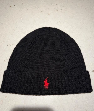 Polo Ralph Lauren mössa - Säljer denna svarta Polo Ralph Lauren mössa. Knappast använd. Nypris 1100. Hör av dig för en snabb affär!