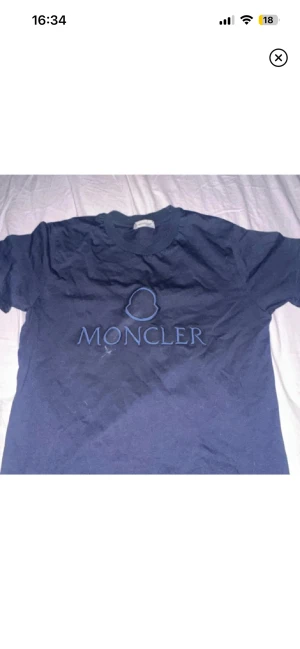 Mörkblå Moncler t-shirt  - Snygg mörkblå t-shirt från Moncler med broderad logga på bröstet. Klassisk rund hals och korta ärmar. Tillverkad i mjuk bomull som känns skön mot huden. Perfekt för dig som gillar stilrena designer och exklusiva märken.