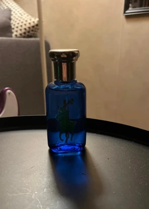 Ralph Lauren Blue Parfym Herr - Snygg och sportig parfym från Ralph Lauren, med blå flaska och ikonisk polospelare. Volymen är 50 ml. Perfekt för dig som vill sticka ut med en klassisk och fräsch stil. OBS: Postar så fort som möjligt!