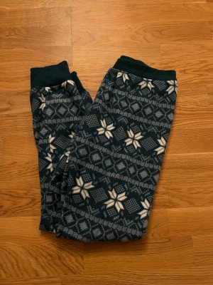 Mönstrade tights från Hunkemöller - Supermysiga tights från Hunkemöller i storlek M. Byxorna är gröna med vitt vintermönster och har ribbade muddar vid midja och benslut. Fint skick!