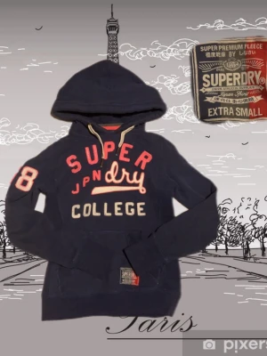 Mörkblå Superdry hoodie med tryck - Mörkblå hoodie från Superdry med stor huva och dragsko. Framsidan har broderat och tryckt text i rött, vitt och beige: 'SUPERDRY COLLEGE' samt siffran 8 på ärmen. Klassisk känguruficka och ribbade muddar. Perfekt för en avslappnad och sportig stil.
